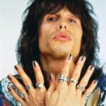 Steven Tyler Displaying His Rings and Black Nail Polish